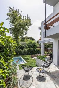 a backyard with a pool and two chairs and a table at Private pool Villa in Athens