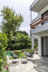 a patio with two chairs and a table in front of a house at Private pool Villa in Athens