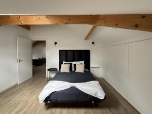 a bedroom with a large bed with white walls and wooden floors at S'apartments in Leiria
