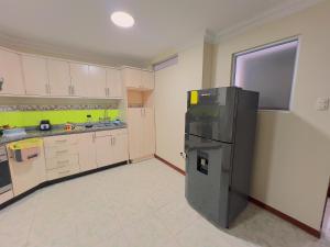 a kitchen with a refrigerator in the middle of it at Departamento en el Centro con Garaje in Loja