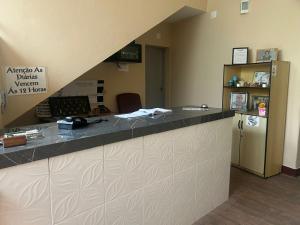 an office lobby with a counter and a refrigerator at Hotel Shangri-la in Três Corações