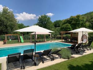 a group of chairs and umbrellas next to a pool at Villa Smaragdis in Čerević