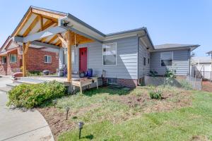 a house with a covered porch with a red door at 7 Mi to Denver Inviting Aurora Home with Yard! in Aurora