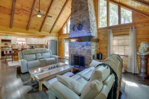a living room with couches and a stone fireplace at Hot Springs Cabin w/ Deck + Mountain Views! in Hot Springs