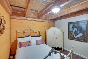 a bedroom with a bed with a wooden wall at Hot Springs Cabin w/ Deck + Mountain Views! in Hot Springs