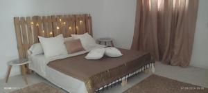 ein Schlafzimmer mit einem Bett mit einem hölzernen Kopfteil in der Unterkunft Diyar Selma in Tataouine