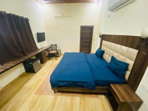 a bedroom with a large bed with blue sheets at Olive Home Stay in Agra