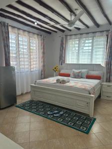 a bedroom with a large bed in a room with windows at Sea la vie - Macheo in Ukunda