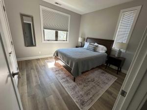 a bedroom with a bed and two windows at Spacious Condo Downtown Traverse City in Traverse City