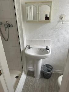 a small bathroom with a sink and a shower at The Stage Door Hotel in Blackpool