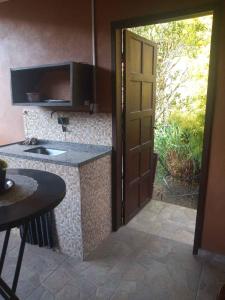 an open door to a kitchen with a sink at Suíte WILVIT in São Pedro da Serra