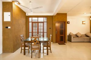 a dining room with a table and chairs and a couch at Peridot Hotels Mount Lavinia in Watumulla
