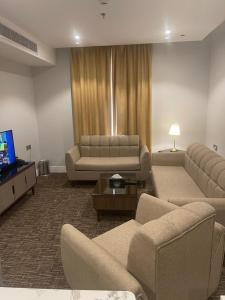 a living room with couches and a flat screen tv at شقق حيات الفرسان للشقق الفندقية in Al Qurayyat