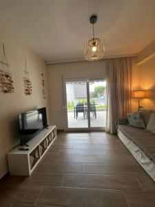 a living room with a couch and a television at Sea Shell in Nikiti