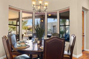 a dining room with a table with chairs and a chandelier at The Debonair Derby by PaseoHomesAZ with Heated Pool in Scottsdale