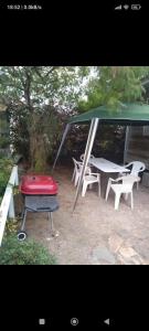 a picnic shelter with a table and chairs and a red seat at Cabaña en Guanaqueros in Guanaqueros