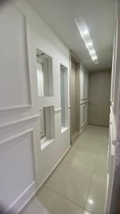 ein leerer Flur mit weißen Wänden und Spiegeln in der Unterkunft Upar Suite Apartamento con Aire Acondicionado y piscina in Valledupar + 7 Fotos