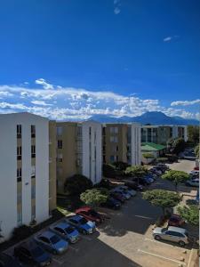 ein Parkplatz mit Autos, die vor Gebäuden geparkt sind in der Unterkunft Upar Suite Apartamento con Aire Acondicionado y piscina in Valledupar