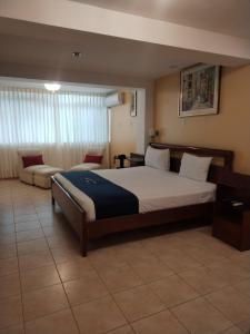 a bedroom with a large bed and a couch at Lucky Star Hotel in Chiclayo