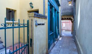 an alley with a blue door and a fence at La Maison Verte -Hypercentre-confort in Troyes