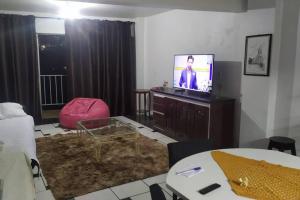 a living room with a television and a room with a table at Liberdade! Apto no centro! in Caçador +1 photo