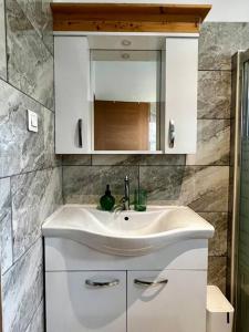 a bathroom with a white sink and a mirror at Fare Apetahi - Maison 2 Chambres in Uturoa +15 photos