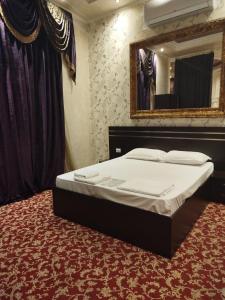 PʼarakʼarImperial Palace Hotel EVN的一张位于带大镜子的房间内的床铺