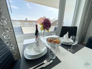 a table with a plate of food and a bottle of wine at Haus Nautic Döse Wohnung 301 in Cuxhaven