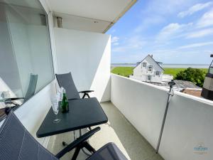 a small balcony with a table and chairs on it at Haus Nautic Döse Wohnung 301 in Cuxhaven