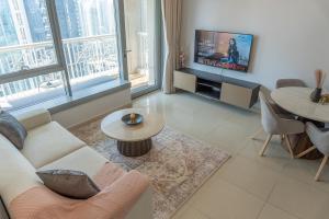 a living room with a couch and a tv at Downtown Oasis, Burj Khalifa Views, Luxury Amenities in Dubai