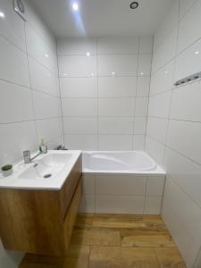 a white bathroom with a tub and a sink at Może nad morze in Gdańsk