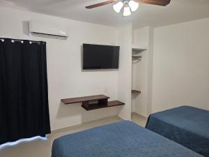 a room with two beds and a television on the wall at HOTEL PLAZA in La Paz