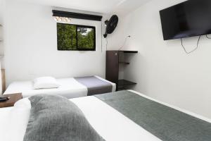 Postel nebo postele na pokoji v ubytování Hotel Palo Alto Laureles