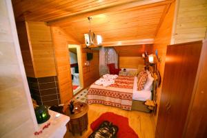 アグヴァにあるAssortie La Villa Hotelの木製の部屋にベッド1台が備わるベッドルーム1室があります。