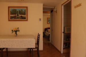 a room with a table with a vase of flowers on it at Cómoda casa para parejas in Coquimbo