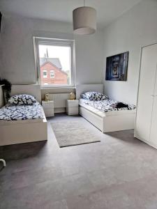 two beds in a room with a window at Grosse Bequeme Wohnung in Recklinghausen