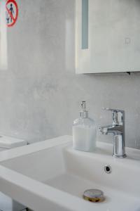 ティラナにあるBejart Apartment 4の石鹸ディスペンサーが付いたバスルームのシンク