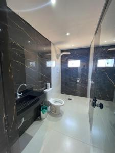 a bathroom with a toilet and a sink and a shower at Suíte Silver 201 com ar condicionado in Santo Antônio do Descoberto