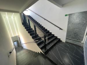 a staircase in a building with black tile floors at Suíte Silver 201 com ar condicionado in Santo Antônio do Descoberto