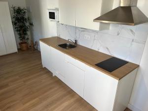 a kitchen with white cabinets and a sink at Casa Gabi in La Sabinita +13 photos