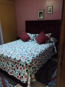 une chambre avec un lit avec une couette dessus dans l'établissement Appartement en corniche Tanger, à Charf 12 autres photos