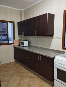 - une cuisine avec un comptoir et un four micro-ondes dans l'établissement Appartement en corniche Tanger, à Charf
