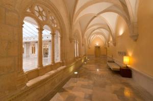 a hallway in a building with arches and windows at NH Collection Palacio de Burgos in Burgos