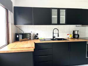 a kitchen with black cabinets and a wooden counter top at Ferienhaus Windmühlenweg mit großem sonnigen Garten -Neu- in Spenge