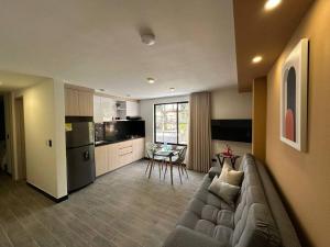 a living room with a couch and a kitchen at Spacio 203 in Cali