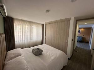 a bedroom with a white bed with a backpack on it at Spacio 203 in Cali