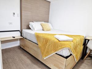 a bedroom with a bed with a yellow blanket on it at Aislado y Relajante cerca Peri, Mira, Majadas, Barrondo H15 in Guatemala