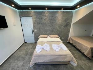 a bedroom with two beds with bows on them at Suíte Silver com sofa cama in Santo Antônio do Descoberto