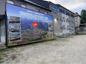 GusinjeHotel Mountain View Inn的大楼一侧的大广告牌