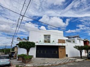 ein weißes Haus mit einem davor geparkten Auto in der Unterkunft Encantadora Confortable Hab Familiar cerca Forum Majadas y Miraflores H14 in El Rodeo
